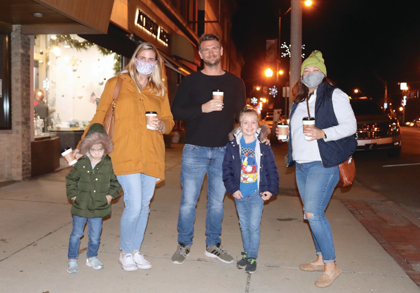 Richelle and Dan Jeffries and daughters Caytlin and Caroline enjoy hot drinks on a crisp night with friend Jamie Selby, right, downtown during Shop Small Saturday.