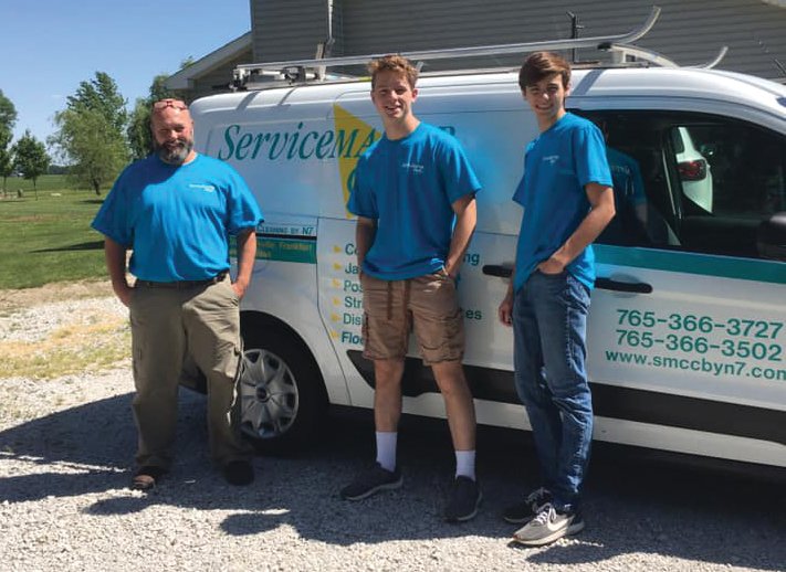 Shane Nolf, first from left, stands in front of his ServiceMaster Clean truck with sons Cole and Dylan, who supervise the business.