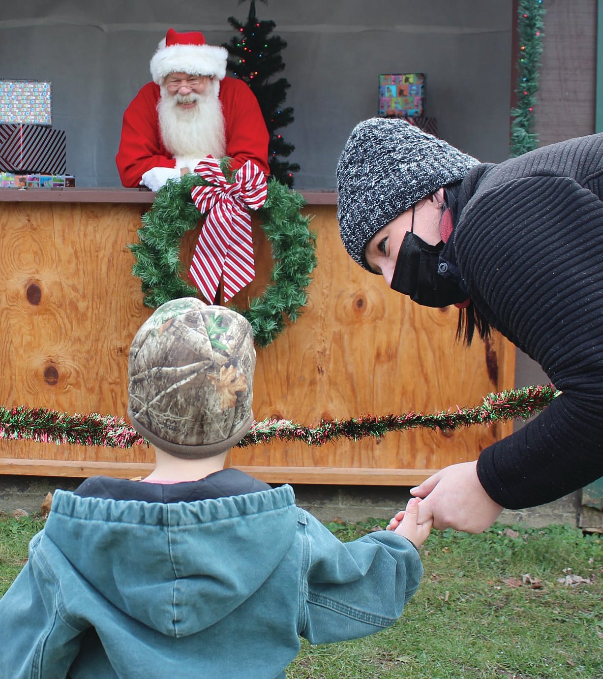 Brooke Busenbark encourages son David Lee Busenbark to greet Santa.