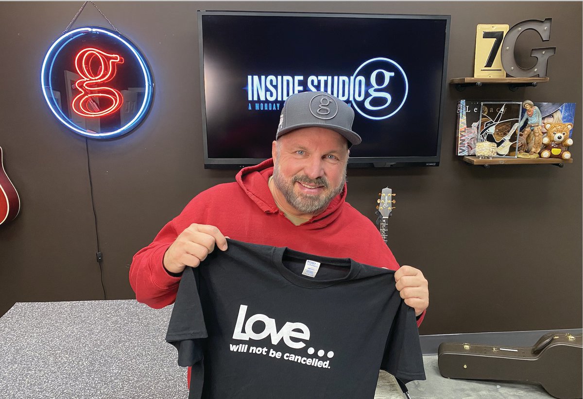 Garth Brooks holds up a T-shirt with a simple inspirational message.