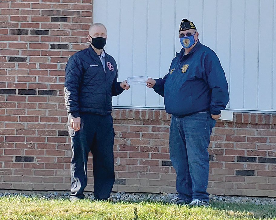 Crawfordsville Fire Chief Scott Busenbark, left, accepts a check from Rodney Strong.