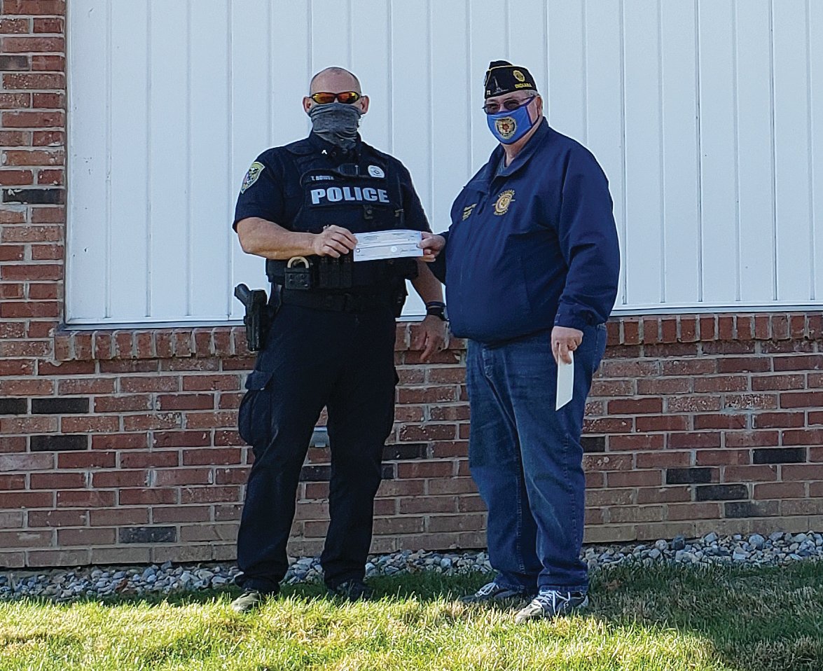 Crawfordsville Police Department representative Tony Bowen, left, accepts a check from Rodney Strong.
