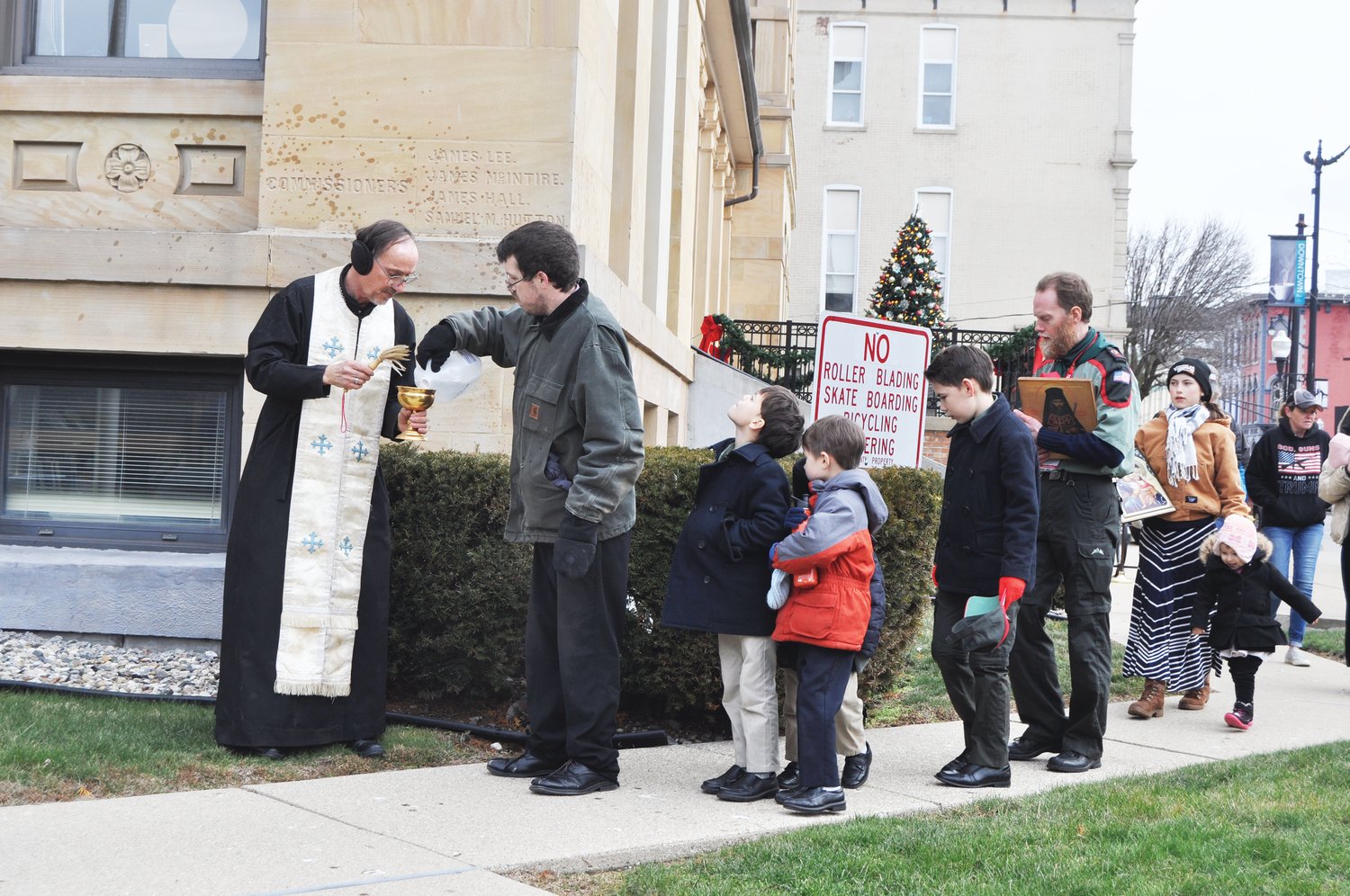 Nick Vancleave pours water into a bowl held by Father Alexis Miller  of Holy Transfiguration Orthodox Church in a blessing of the Montgomery County Courthouse during a Pray Together for America event Wednesday. In remarks, Miller said the nation was facing a