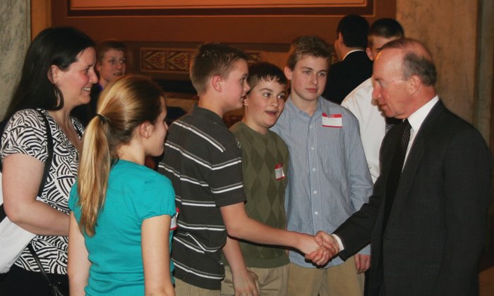 Then-Indiana Gov. Mitch Daniels greets Crawfordsville middle school students at the Indiana Statehouse in 2009, as Carnegie Museum of Montgomery County executive director Kat Burkhart looks on. The museum