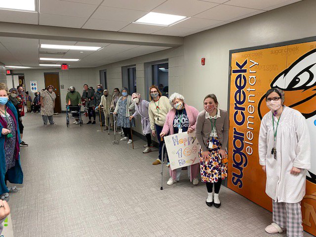 Sugar Creek Elementary School teachers lined the hallways dressed as 100-year-olds to welcome students on the 100th day of in-person school Thursday.