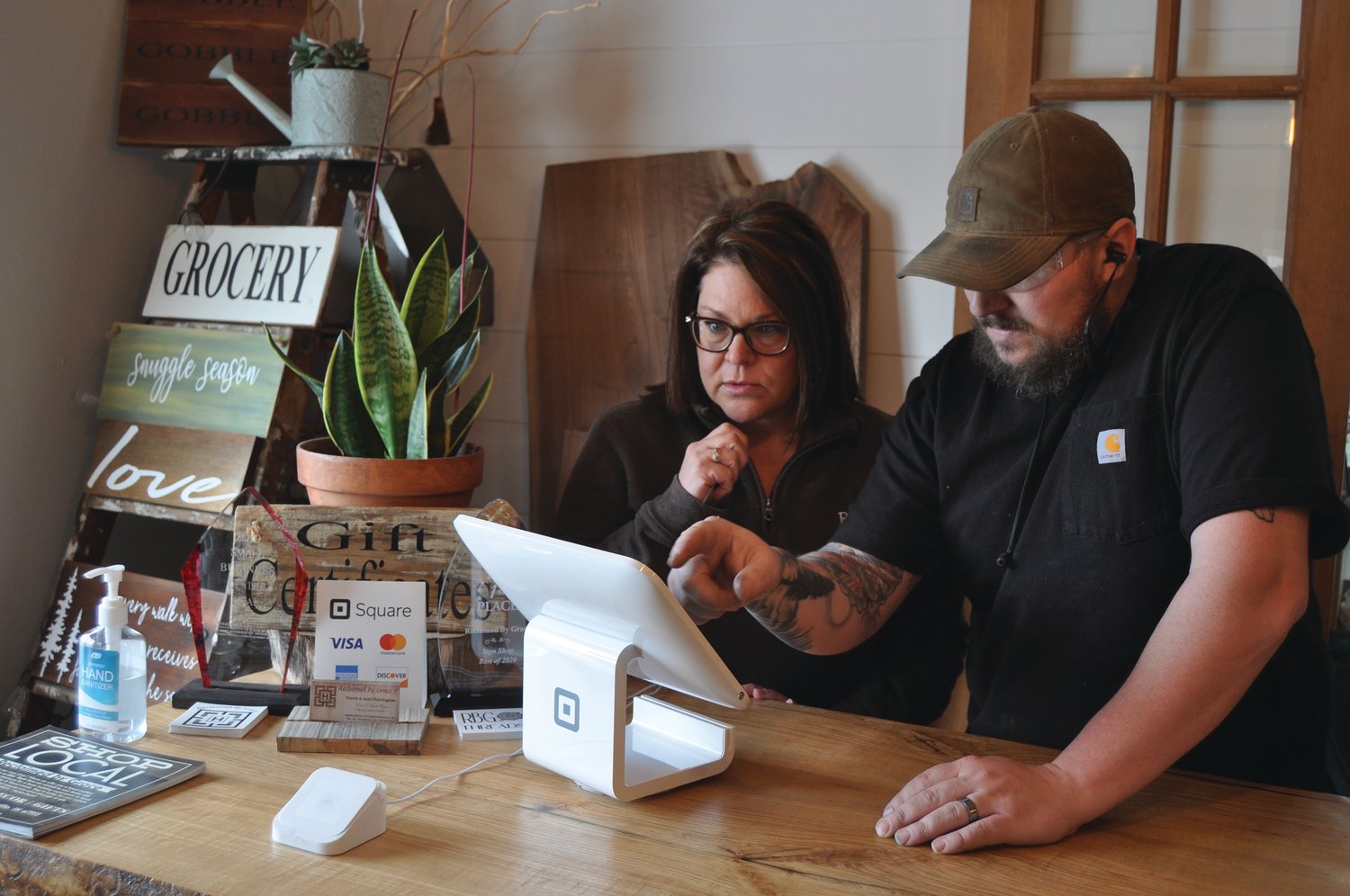Travis Harrington, right, and Jami Harrington, owners of Reclaimed by Grace, use a Square device at the store Tuesday. Fusion 54 is seeking funding for an entrepreneur program and small business development and support.