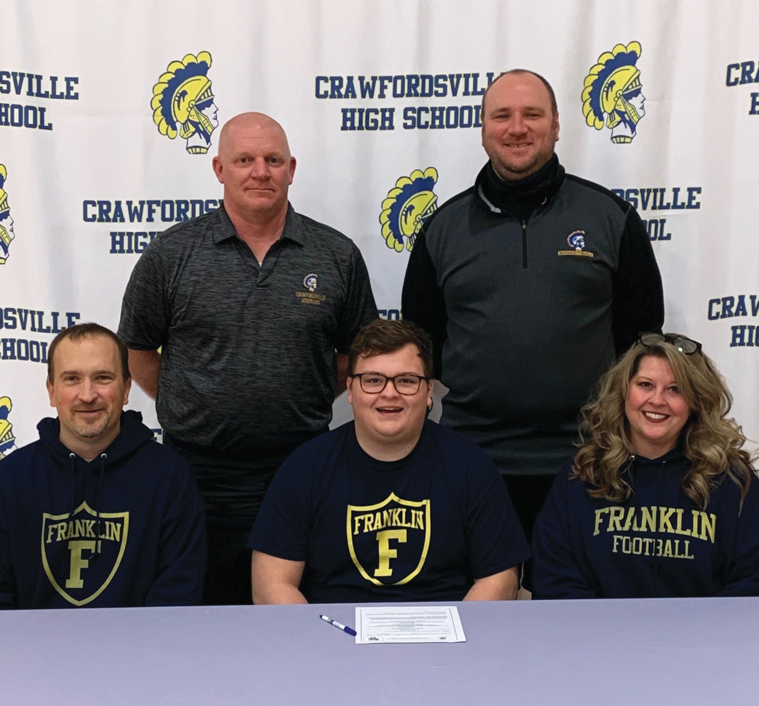Crawfordsville senior football lineman Corbin Smith has committed to play at Franklin College. PICTURED: Corbin is joined by his parents, Scott and Michelle Smith, Crawfordsville head football coach Kurt Schlicher and assistant coach Sean Gerold.