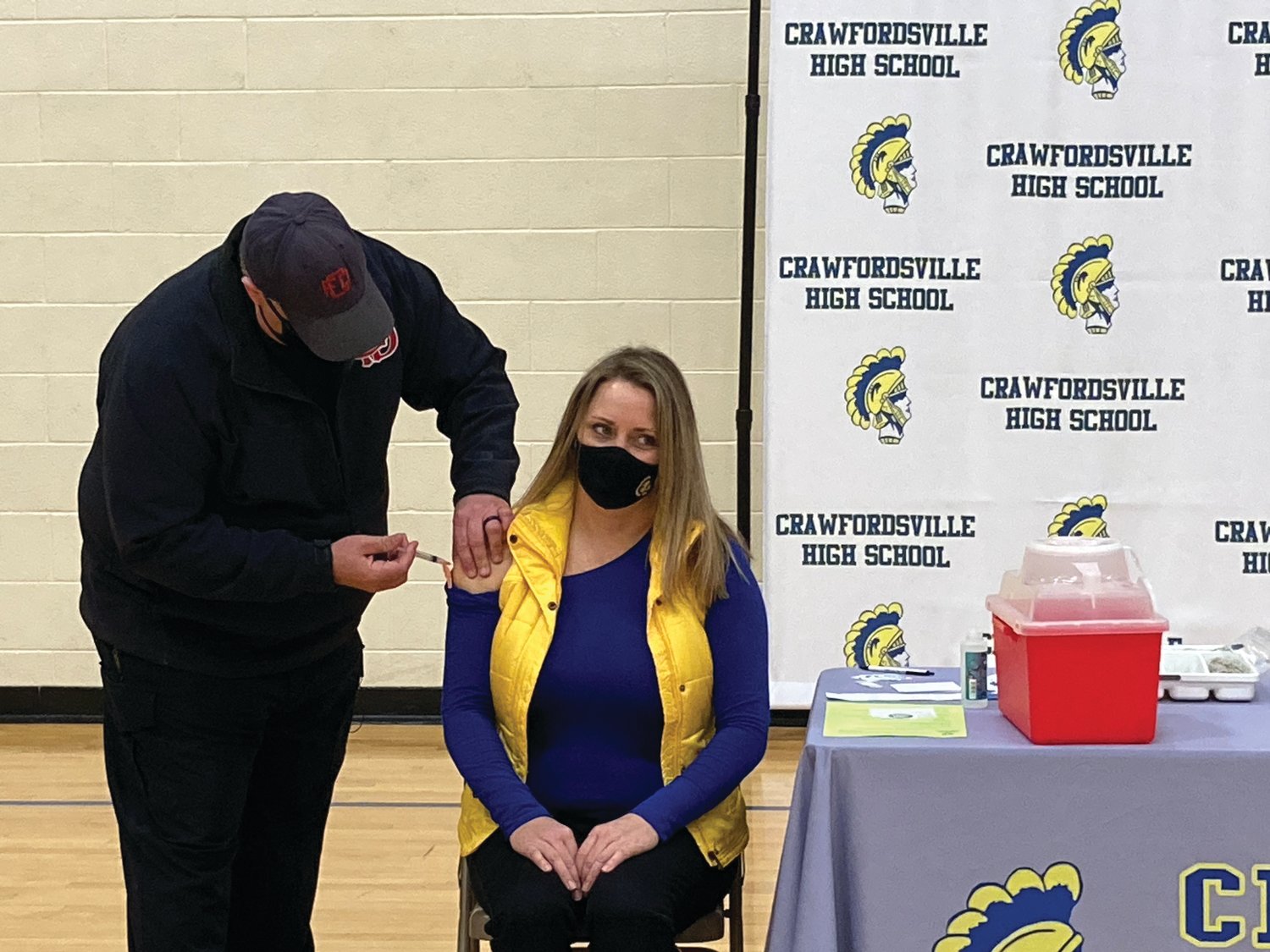 Carrie Jones, a fifth grade teacher at Hoover Elementary, receives a COVID-19 vaccine from community paramedic Joe Crane at Crawfordsville High School on Monday.