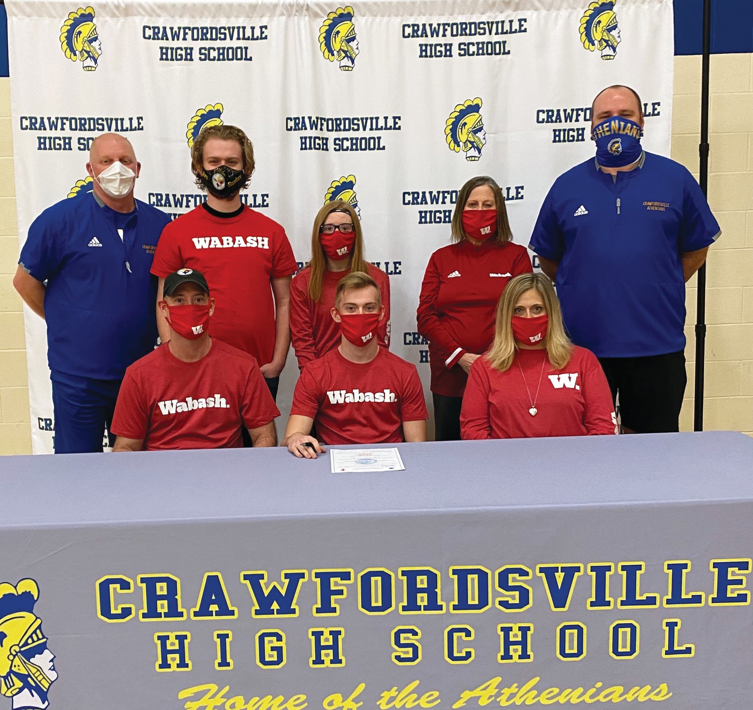 Crawfordsville football player and senior Andrew Martin will continue his career at Wabash College in the fall. PICTURED: Front Row L-R Andrew’s father, Jesse Martin, Andrew, mother, Stephanie Wethington. Back Row L-R Crawfordsville coach Kurt Schlicher, brother, Peyton Suiter, sister, Madison Martin, grandmother, Ginger Collins, and assistant football coach Sean Gerold.