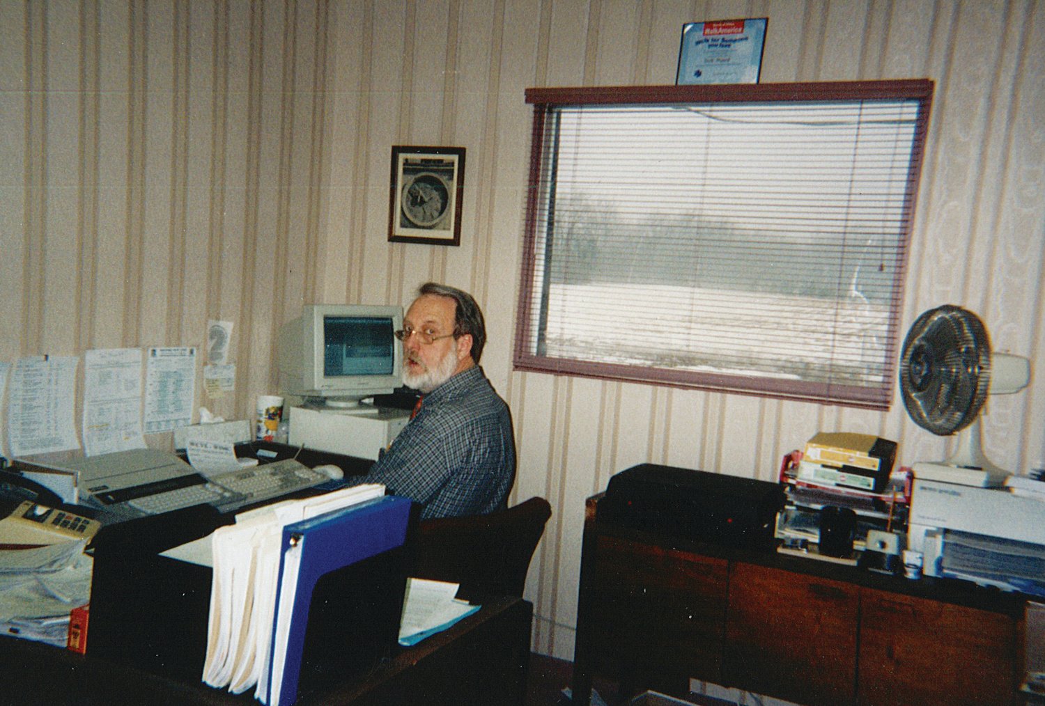 Dick Munro works at his desk in the WIMC/WCVL offices in 1990. Munro, the stations