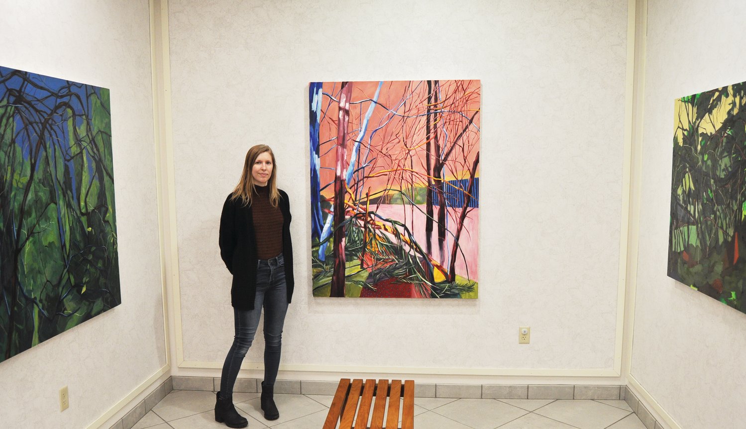 Caitlyn Brandt stands next to her paintings on display at Crawfordsville District Public Library