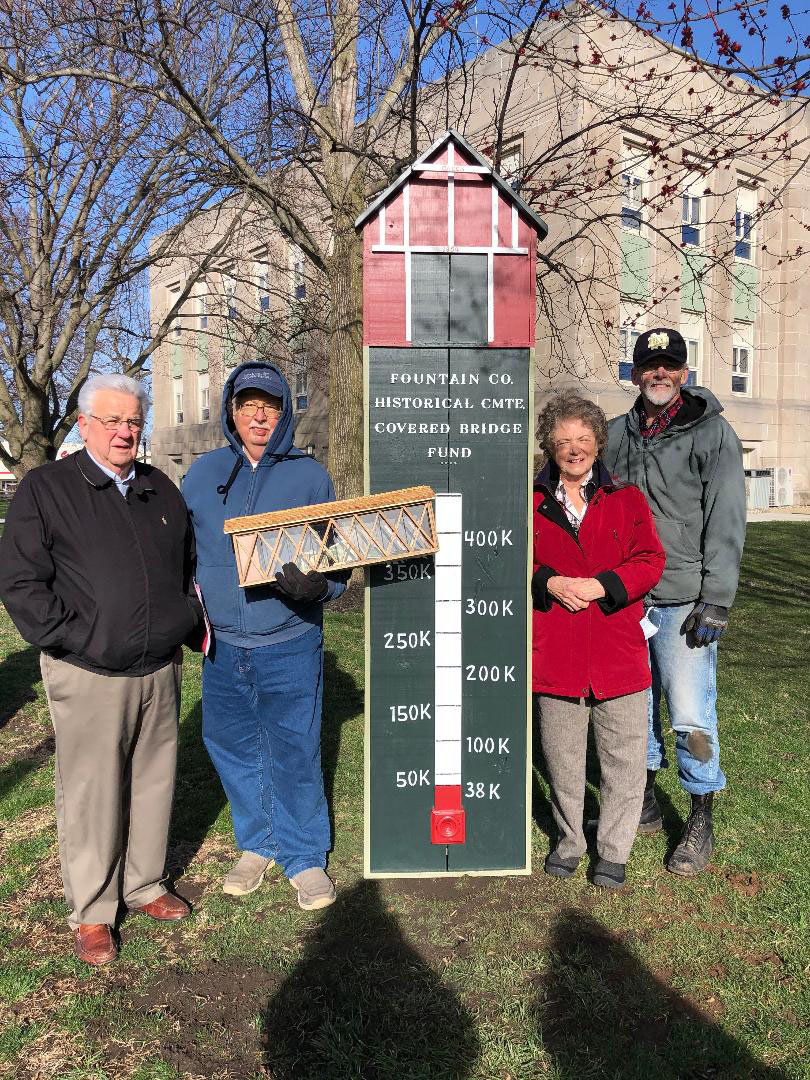 The Fountain County Historical Committee is raising funds to preserve the Cade’s Mill Covered Bridge south of Covington. From left is Jim Hegg, Fountain County Art Council president; Henry Schmitt, historical committee chairman; Carol Freese, Fountain County historian; and Bob Dowell, thermometer creator.
