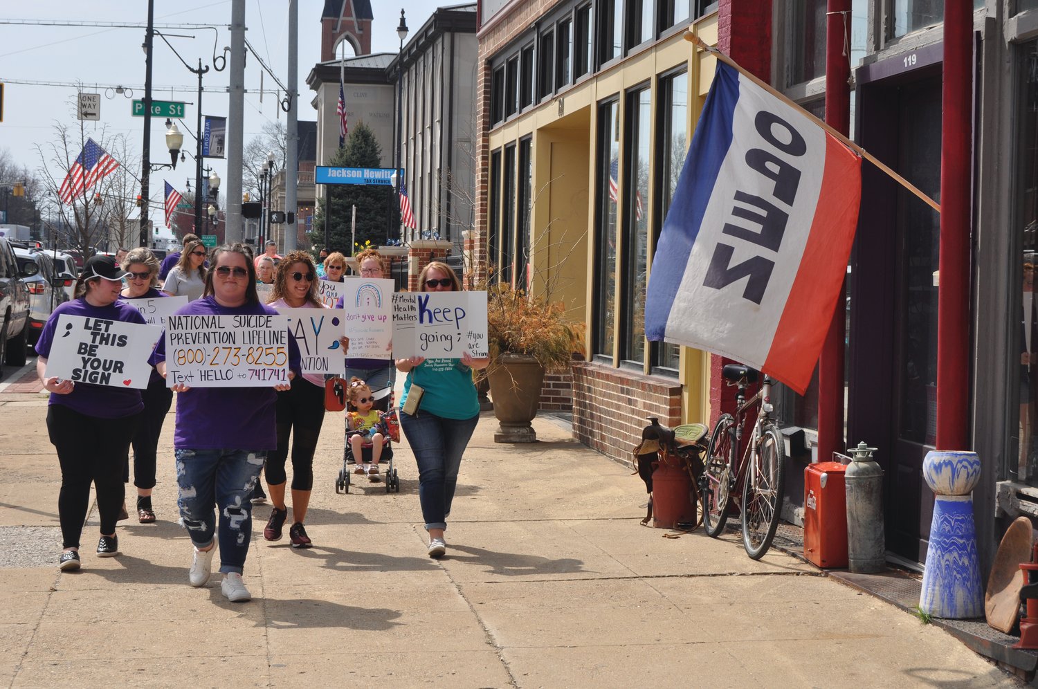 Walkers hold signs to raise awareness of suicide prevention during the Walk of Hope in downtown Crawfordsville Monday.
