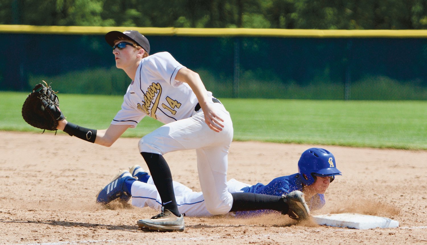 Austin Motz dives back in safely at first base during a sectional game against Lebanon in 2019.