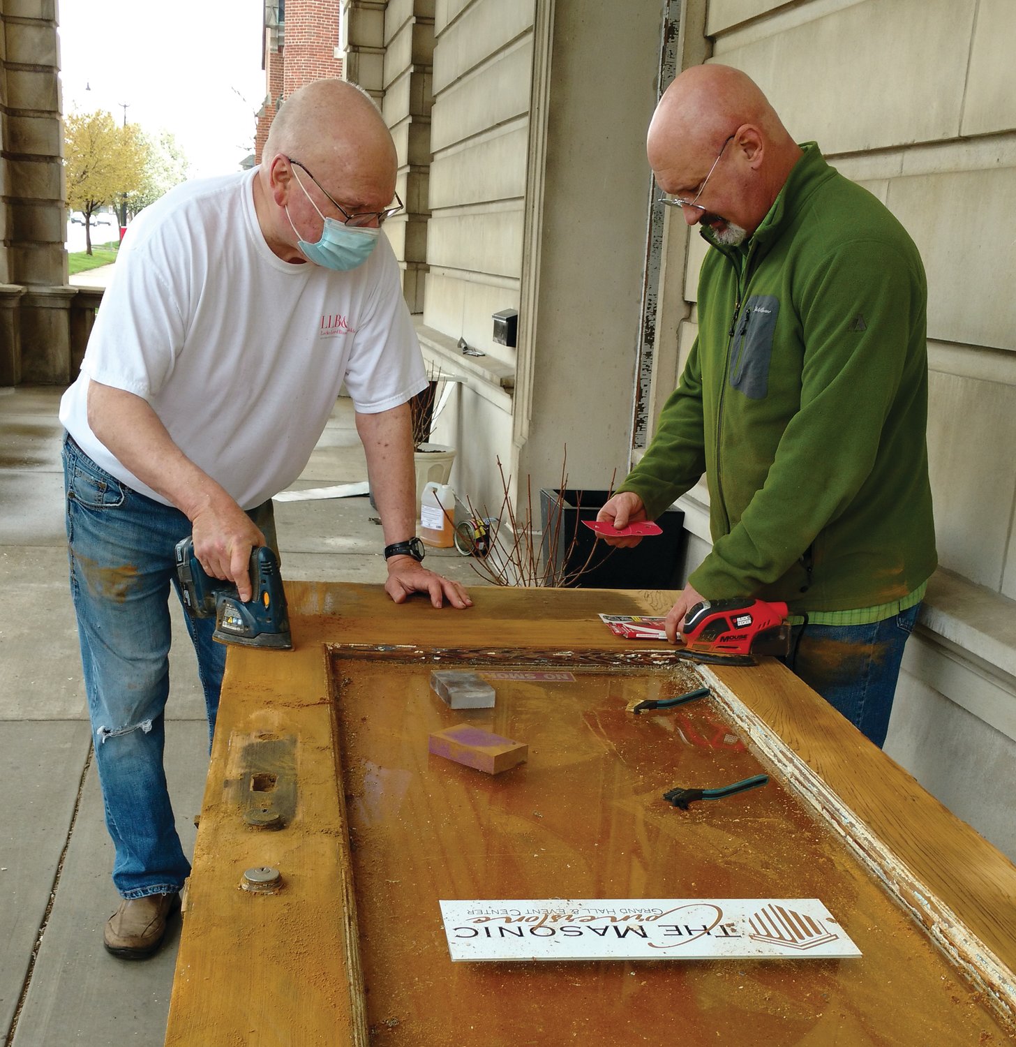 Crawfordsville Masonic Temple Foundation board members, Mike Reidy, left, and Scott Wheeler work on the entry doors of the Masonic Cornerstone Saturday. One side of one door was stripped of the existing deteriorating paint layers back to the original wood. The board is working on many projects to preserve the historic structure formerly known as the Masonic Temple. For more information on how to donate, visit www.themasoniccornerstone.com or call 765-366-2880.