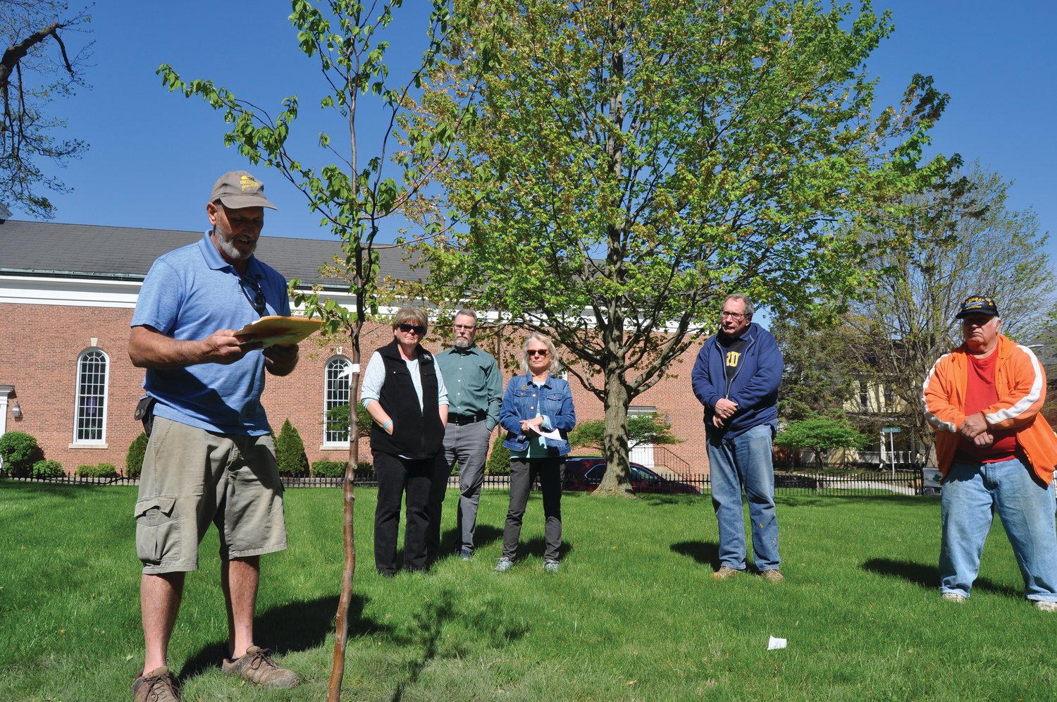Mark Davidson, owner of Davidson’s Greenhouse & Nursery, speaks about his late friend Don Bickel as members of Crawfordsville Main Street and Bickel’s son, Jeff, look on at the Lane Place Friday. Main Street planted an American Hornbeam tree in tribute to Don Bickel, who was a local naturalist.