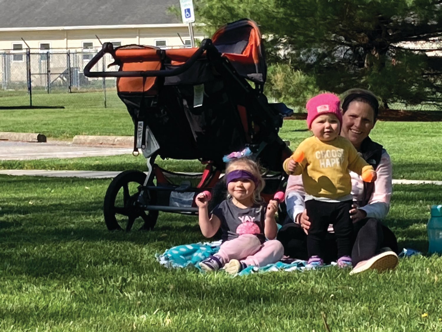 One-year-old Madison Nichols (in the pink hat) and her sister Julia Nichols, 2, shake rattles with their mother, Mindy Nichols, during Story Time at the Sugar Creek Trail on Wednesday.
