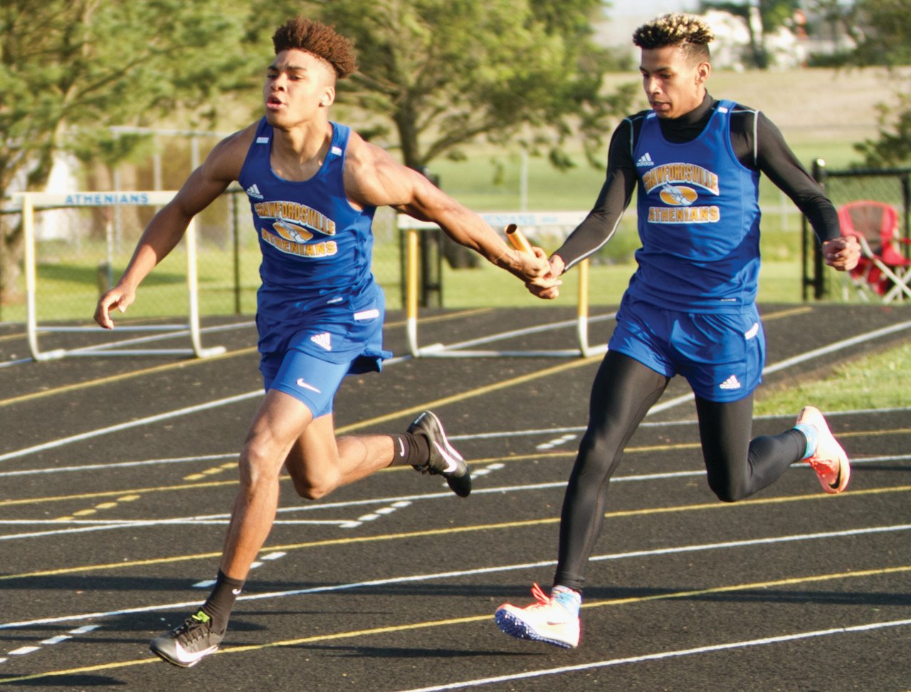 Crawfordsville's Mikale Willis takes the Baton from Tyeson Fuller in the 4X100 meter relay.