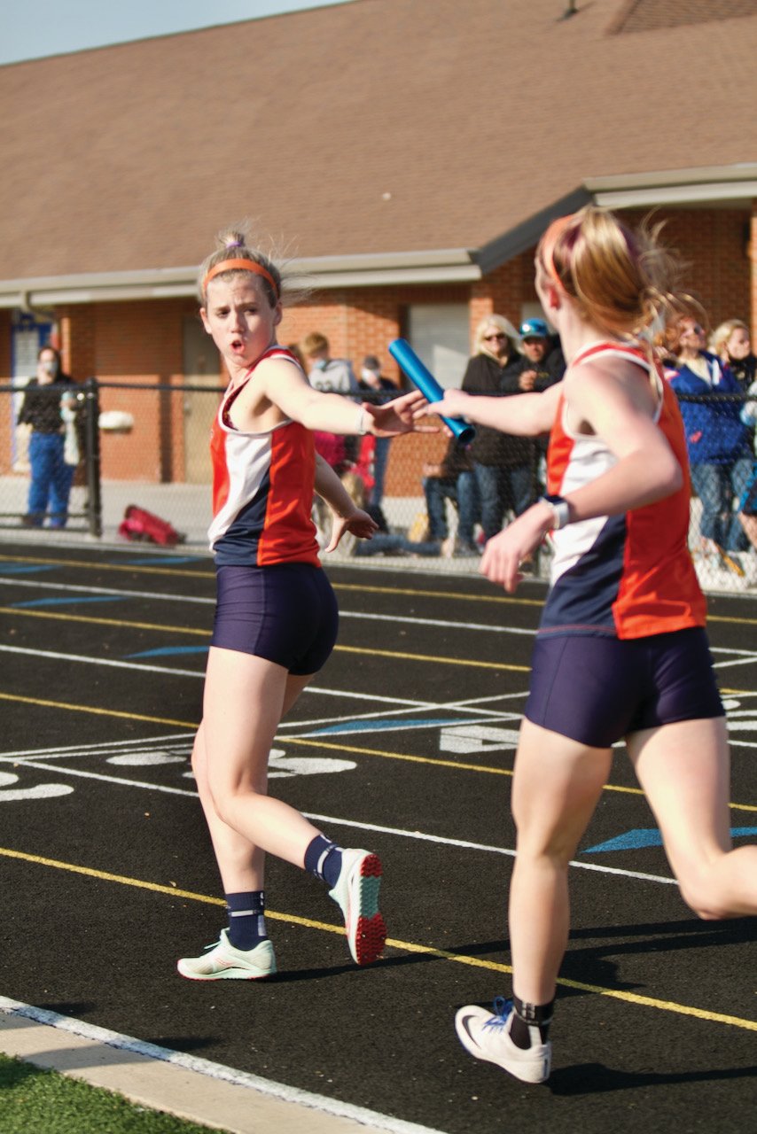 North Montgomery's Maggie Michael hands Claire Bonwell the baton for the final leg of the 4X800 meter relay.