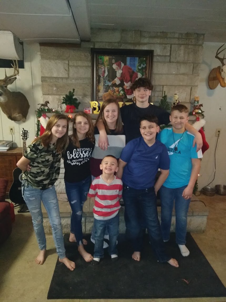 Carson Collins, second from left in the front row, is one of six children. The children pose with their mother, Tawna Collins (in the striped sweater.)
