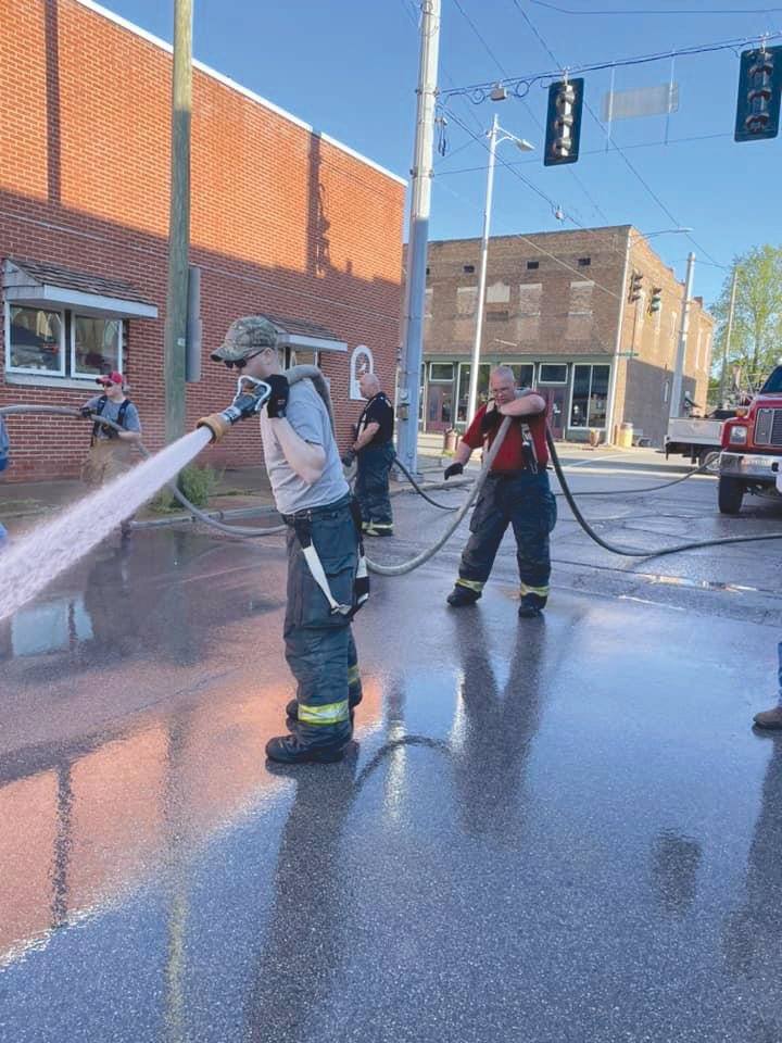 Waynetown volunteer firefighters clean the street ahead of the town's new festival.
