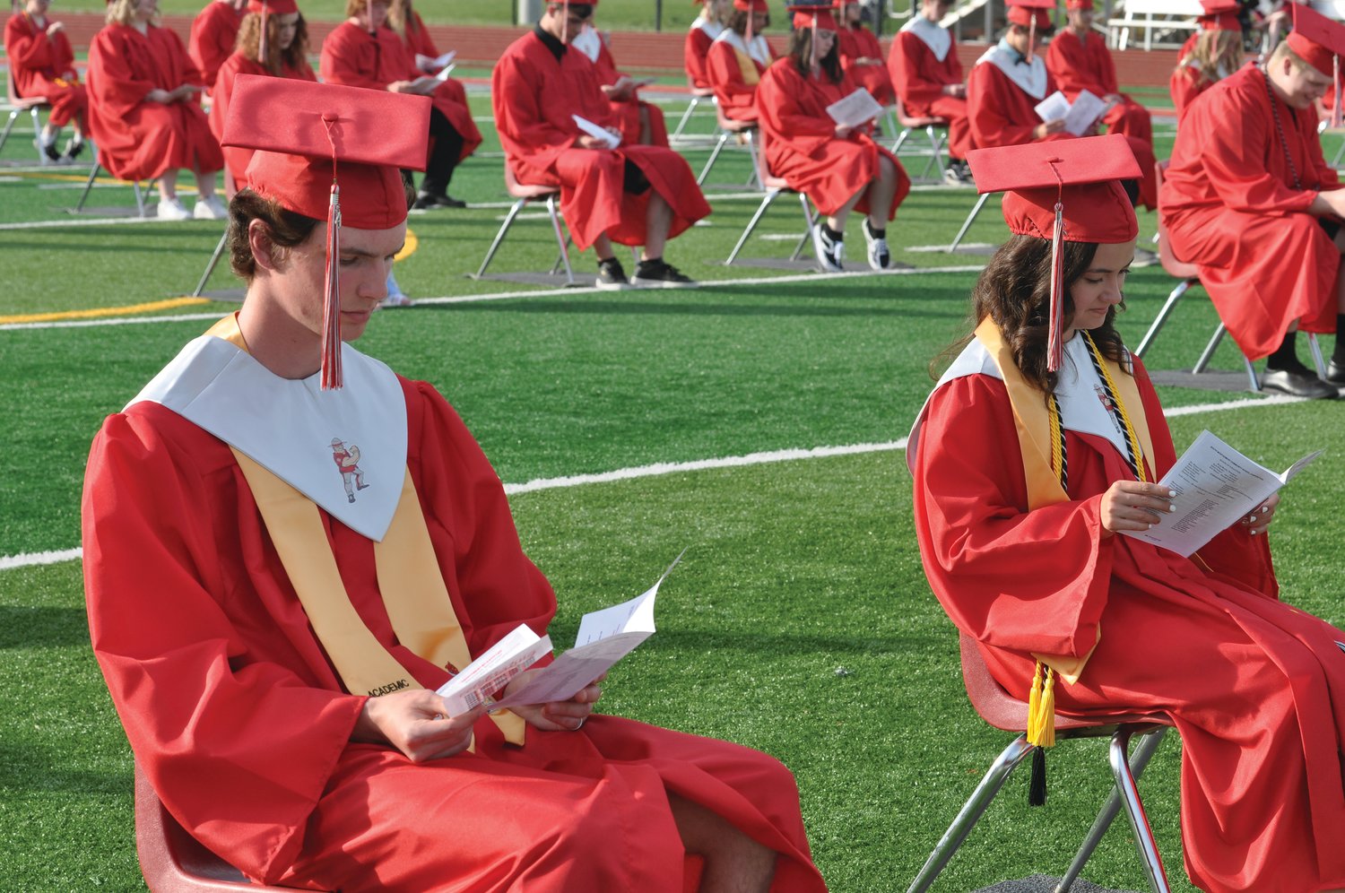 Graduating seniors look at their programs during commencement exercises at Southmont High School on Friday.