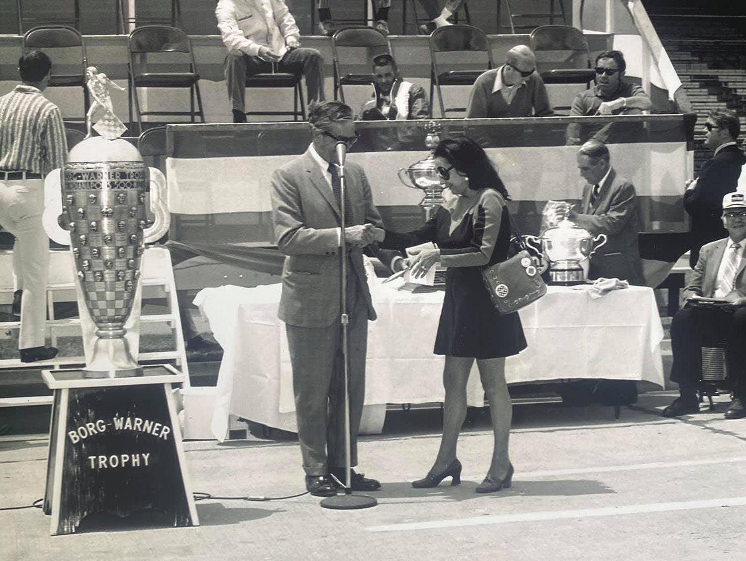 Bettie Cadou is given her silver badge by Tony Hulman at the Indianapolis Motor Speedway in 1971. Cadou was the first woman granted access to the pits and garage area at MS.