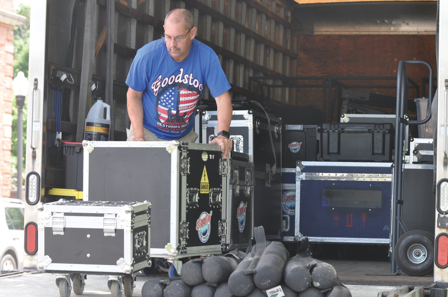 Rich Bell of Sizzlin Sound Productions unloads equipment Thursday for the Strawberry Festival stage at the Lane Place. Steve Trent and Small Town and Elvis tribute artist Steve Klush are among the headliners of this year.