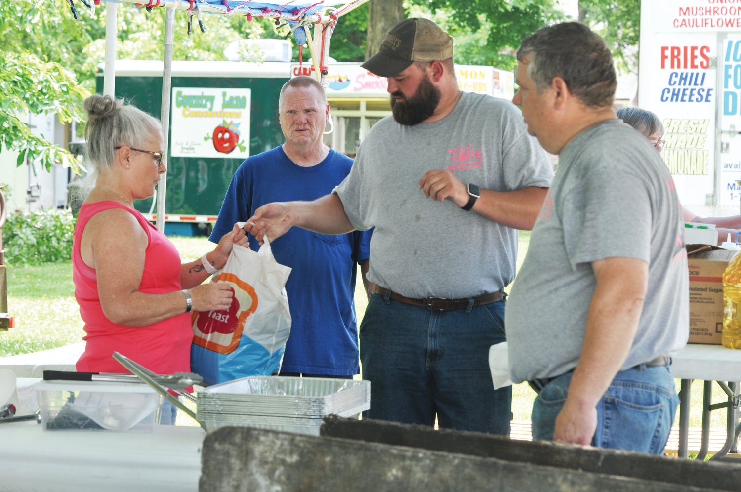 Members of cancer support group Journey of Hope set up a booth Thursday for the Strawberry Festival on the Lane Place grounds. The festival kicks off today.