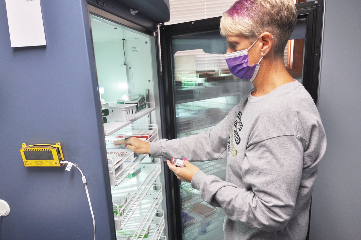 Montgomery County Health Department Preparedness Coordinator Cindy Bushong removes Moderna vaccine from a refrigerator at the health department.