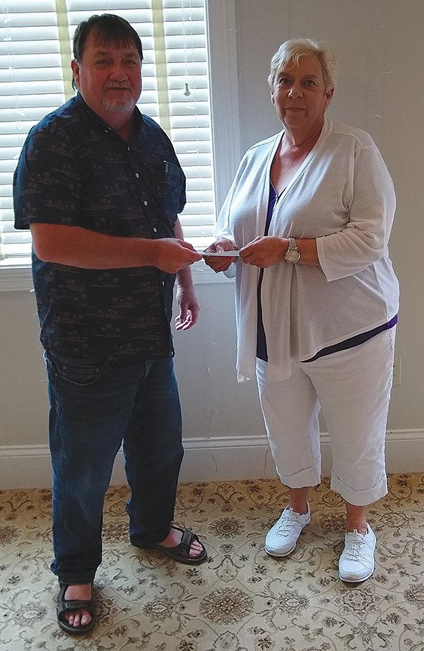 Cindy Biddle, representing Relay for Life, accepts a $1,000 donation from Rotary Club Treasurer Rod Curran.