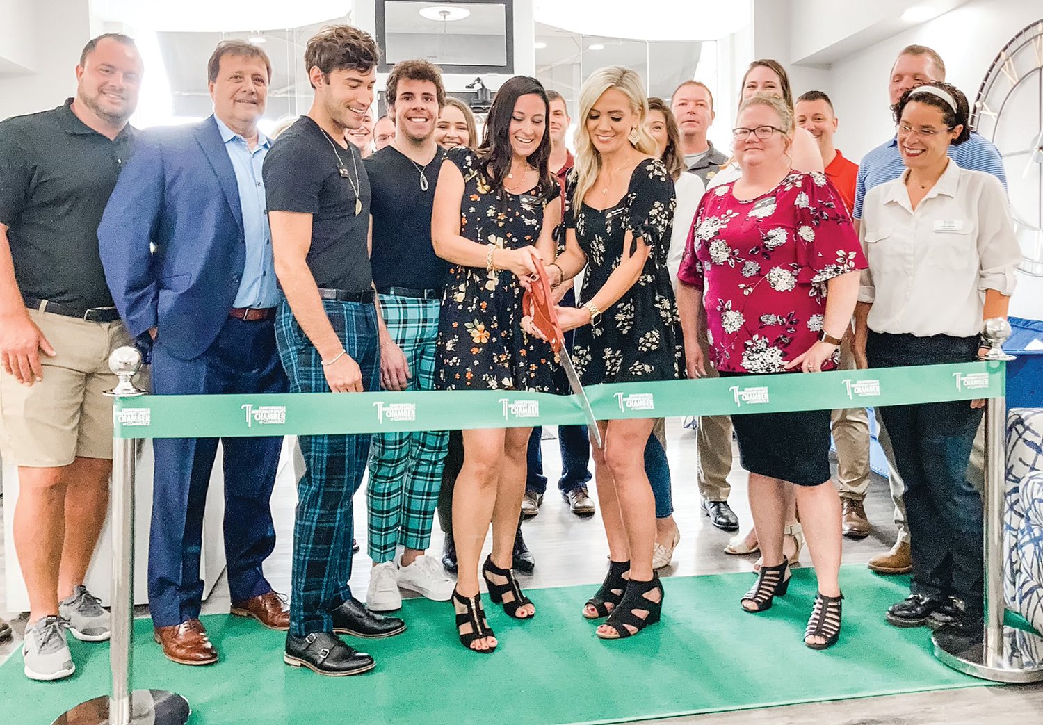 Kasey Ferguson and Rachel Artz cut a ribbon during the grand opening ceremony and open house for Hive Realty Group, 111 N. Washington St. Also pictured are agents, Greg Keyler, Doug Pillow, Jade Perry, Xavier Yankey, Taylor Nine, Ashlee Pritchett, Paige Hewitt, Melanie Thurston and Clark Dale.