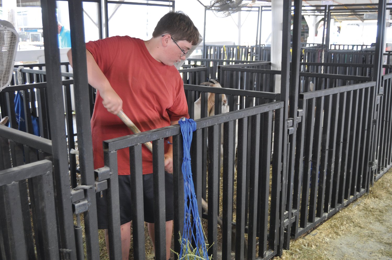 Ethan Moffitt cleans a barn stall Monday at the Montgomery County 4-H Fair.