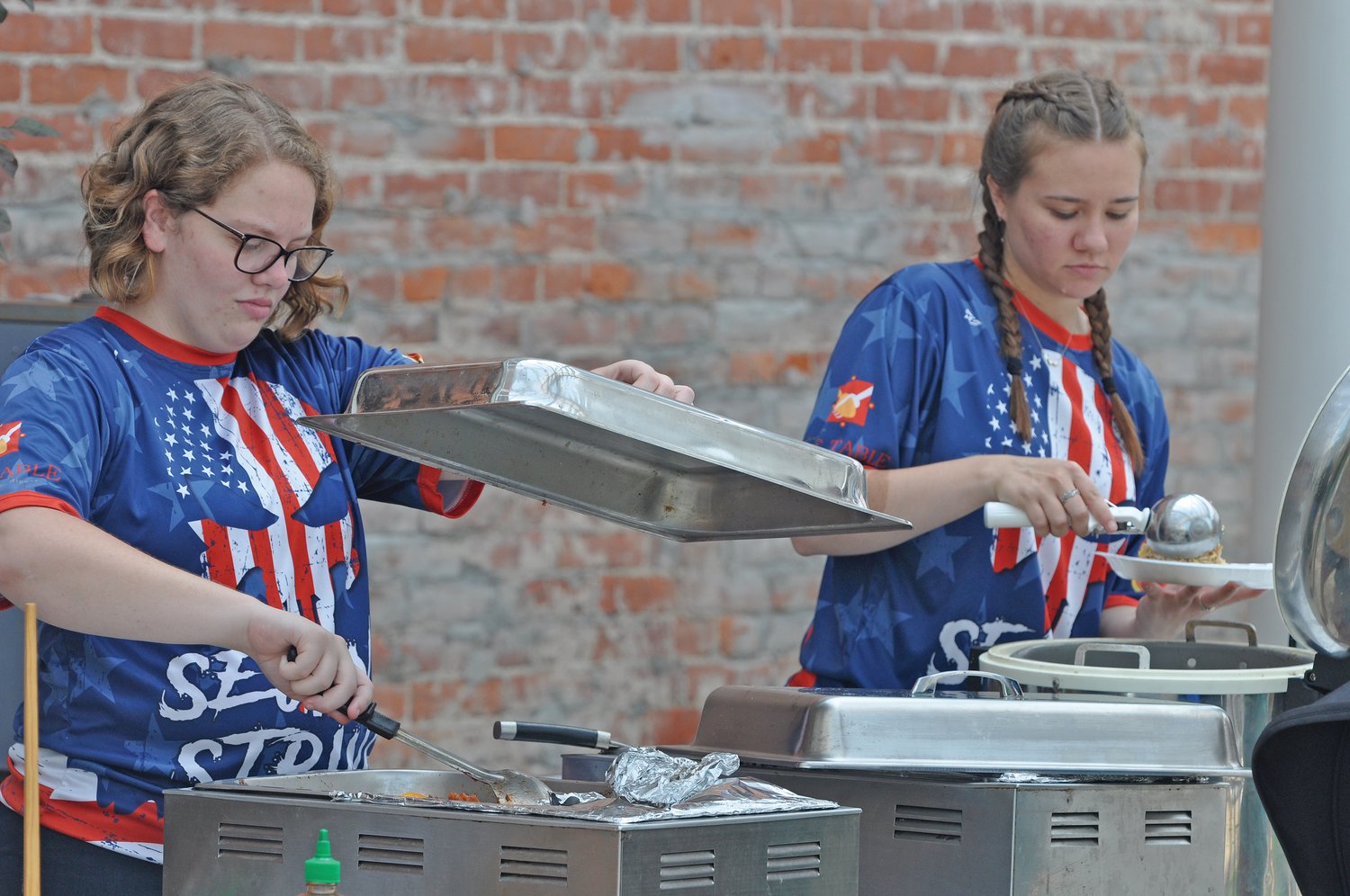 Lauren Minks, left, and Cassidy Crull serve food from China Inn during Crawfordsville Main Street