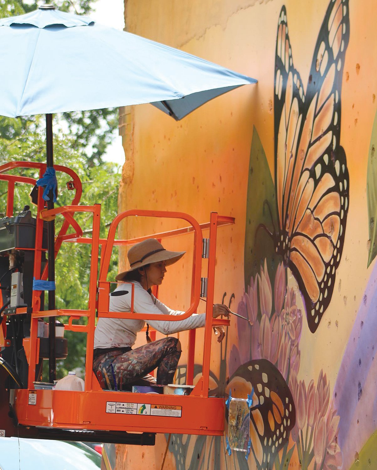 An artist works on the mural in Covington.