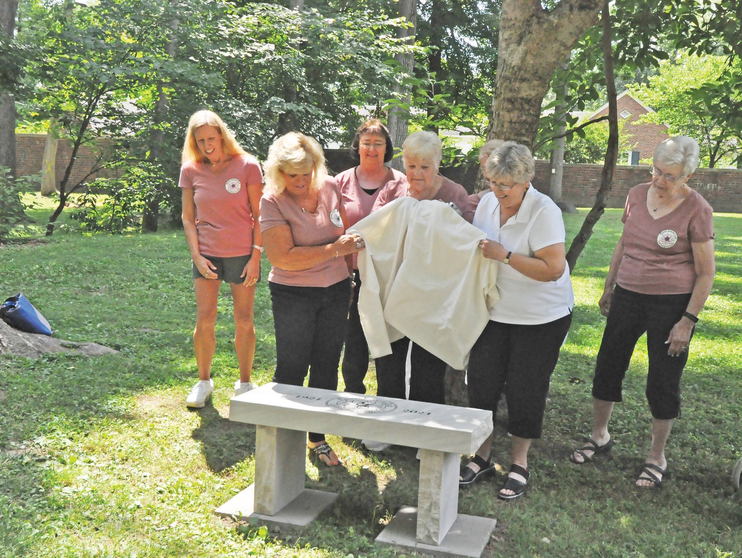 Flower Lovers Garden Club members unveil a bench dedicated to the City of Crawfordsville in honor of the club’s 100th anniversary on the grounds of the General Lew Wallace Study & Museum on Wednesday. The bench was made by Young & Company Rock Art & Design.
