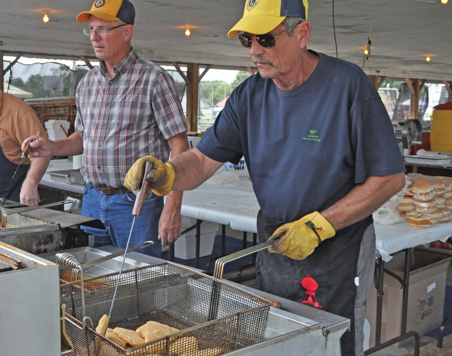 EJ Dixon fries fish alongside Alan Hedge at the Ladoga Lions Club Fish Fry on Friday. The 81st annual event featured live music, fireworks, carnival games and vendor booths.