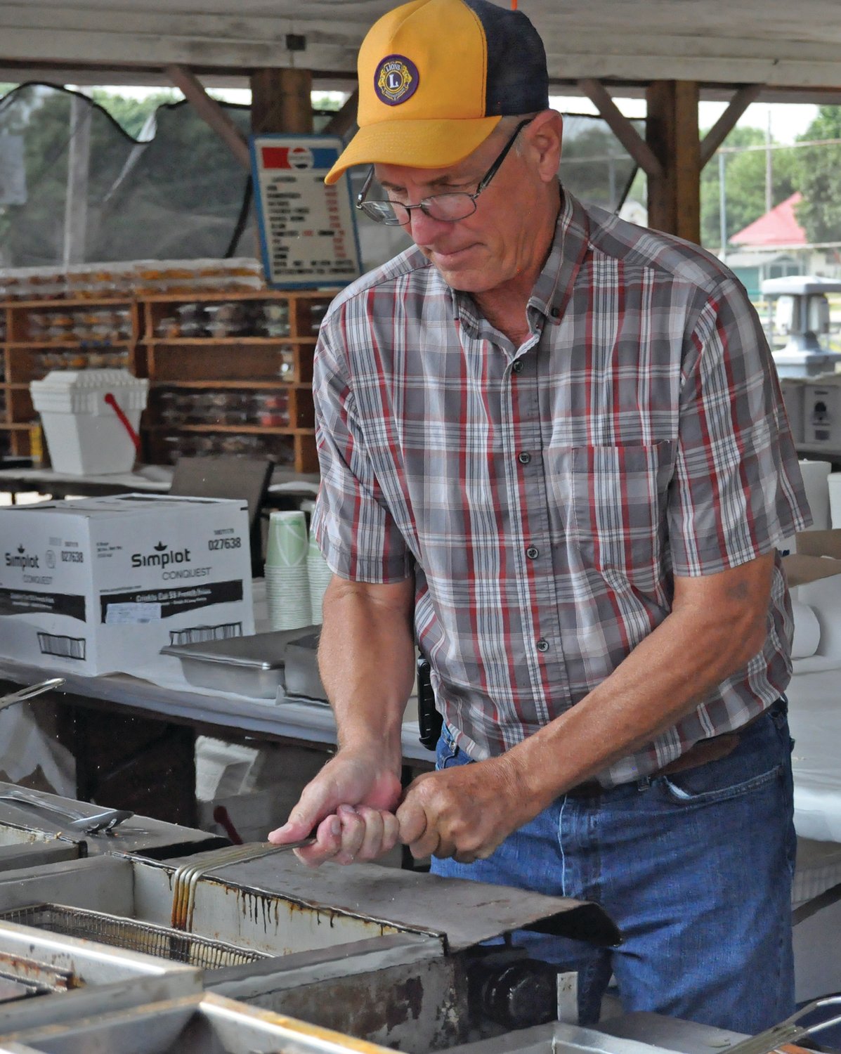 Alan Hedge places a fry pot in a vat at the Ladoga Lions Club Fish Fry on Friday. The 81st annual event featured live music, fireworks, carnival rides and vendor booths.