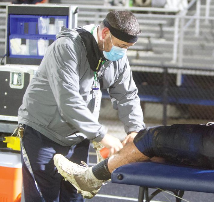 North Montgomery athletic trainer Isaac Hook tends to a Charger football player last fall.