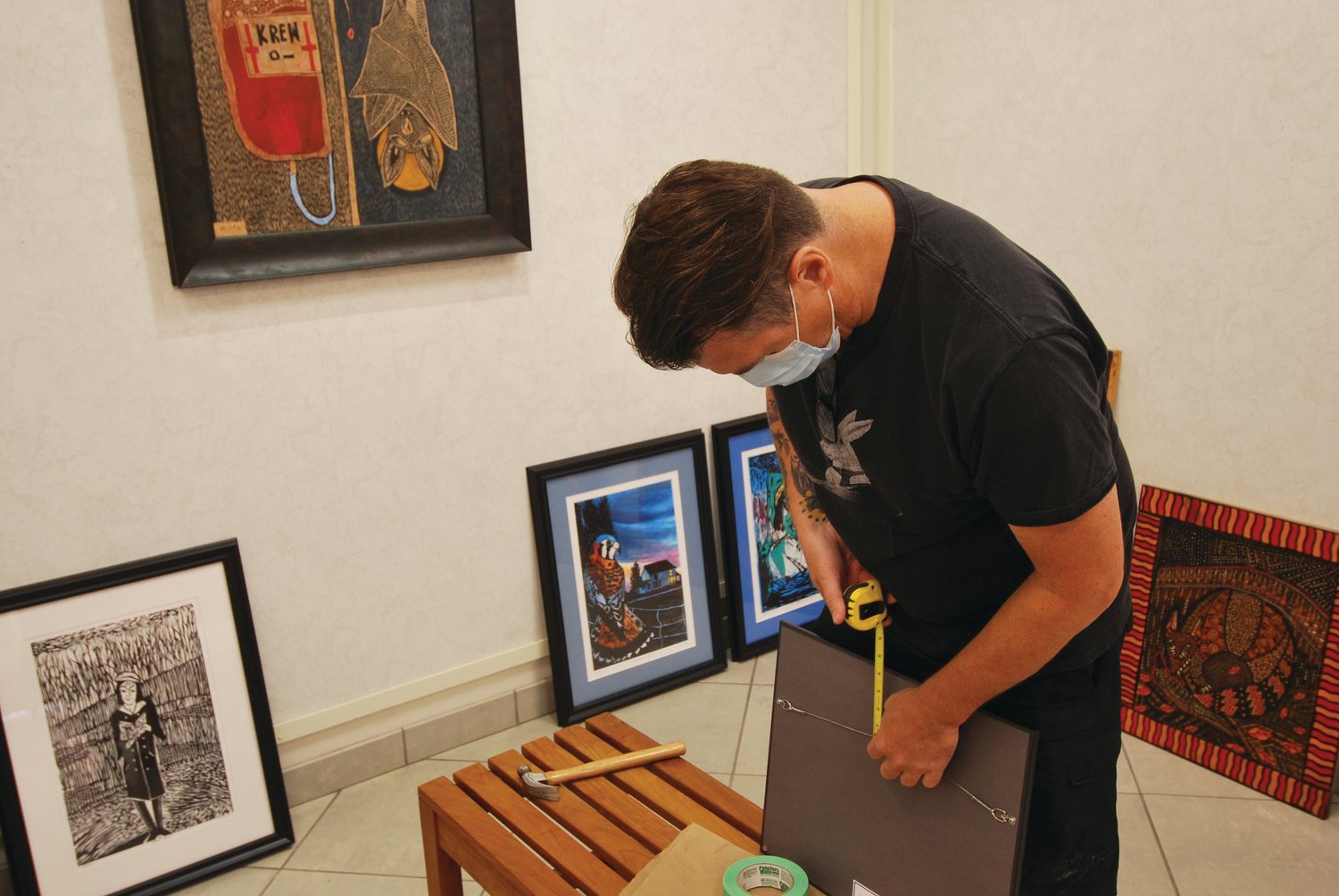 Matt Rees measures a picture frame while installing his art exhibit in the Mary Bishop Memorial Gallery at Crawfordsville District Public Library. Rees