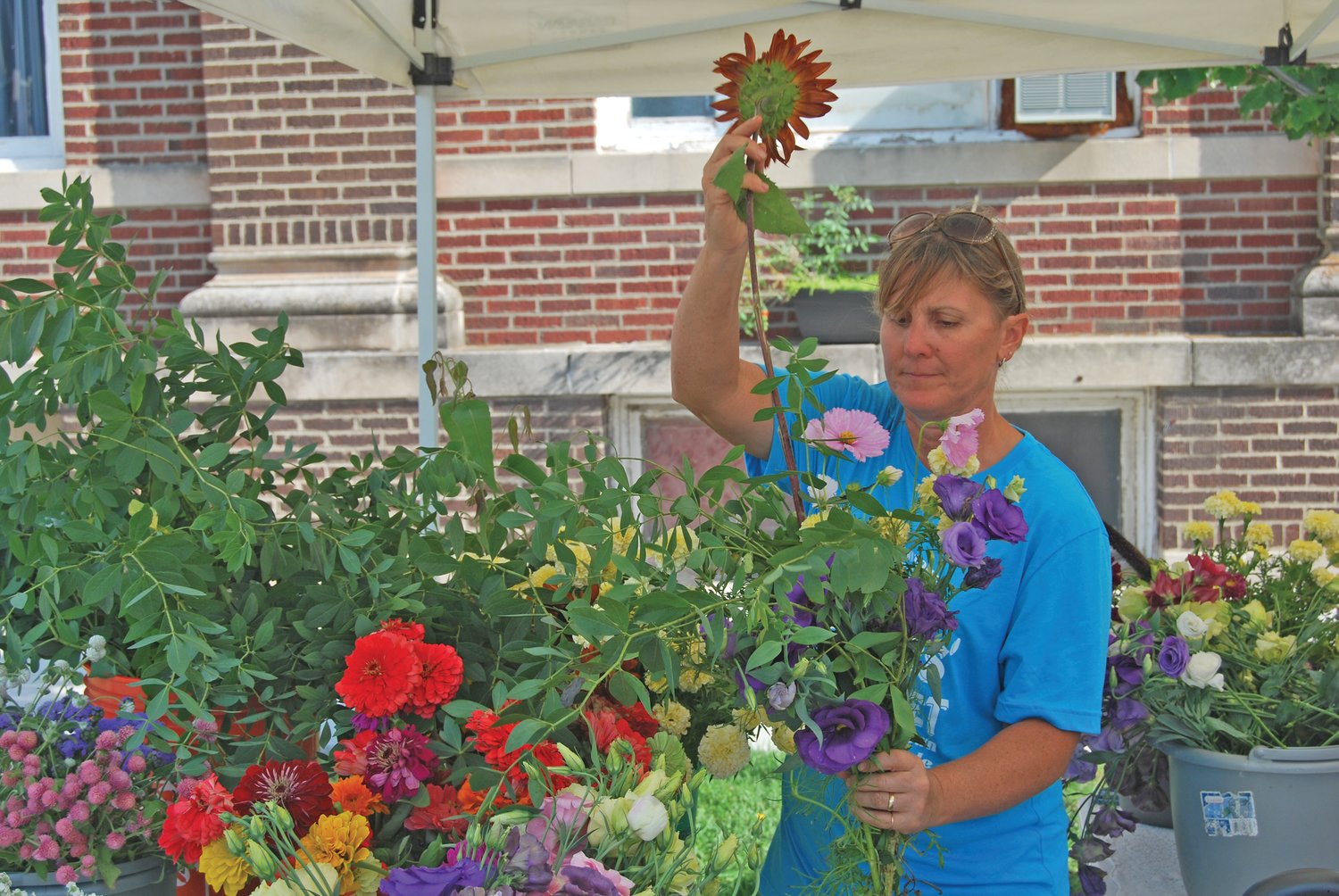 Jamie Smith of Fall Creek Farm arranges a flower bouquet at the Crawfordsville Farmers Market Saturday.
