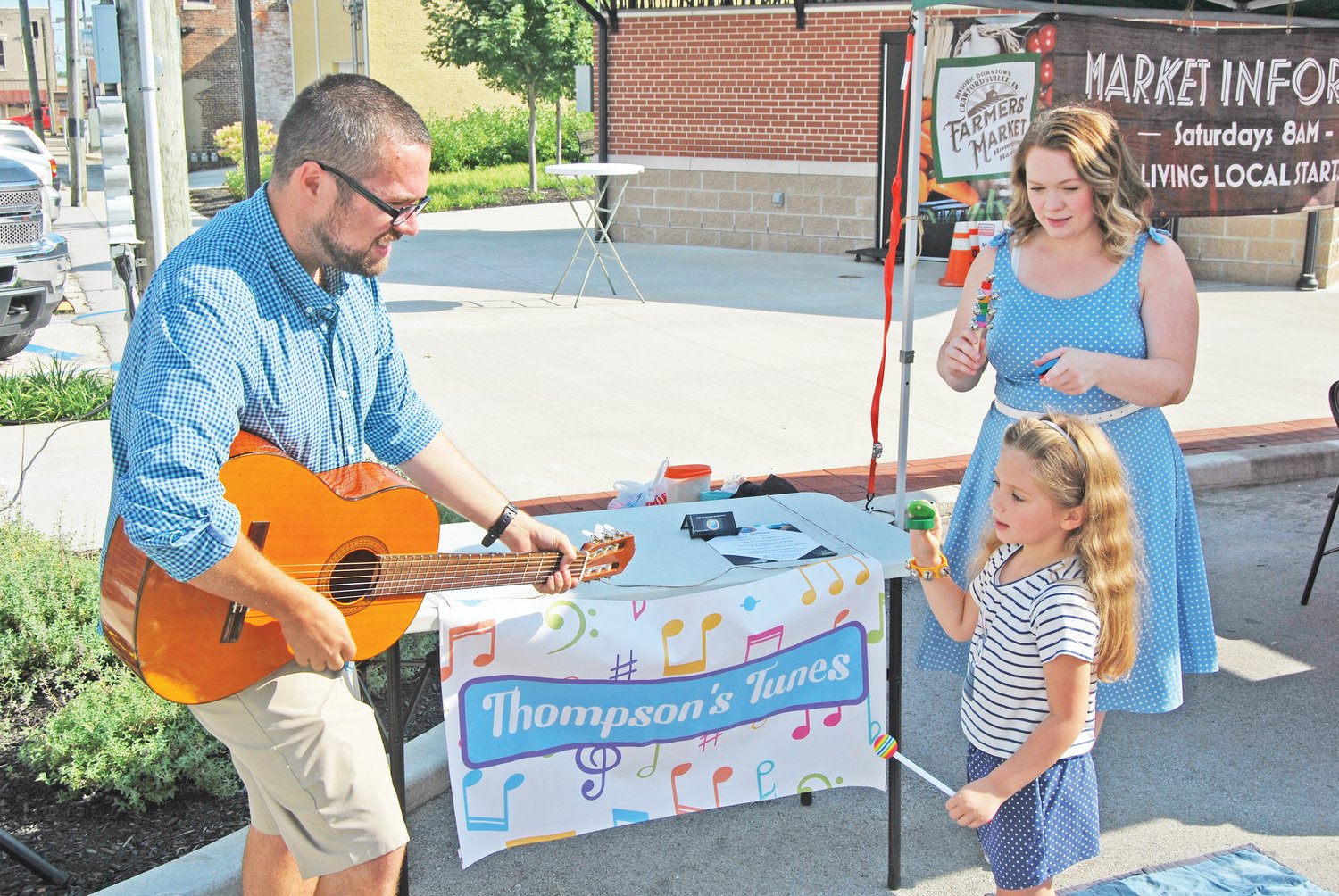 Kerstin Wilson, 5, keeps the beat as Tyler and Bailey Thompson perform children