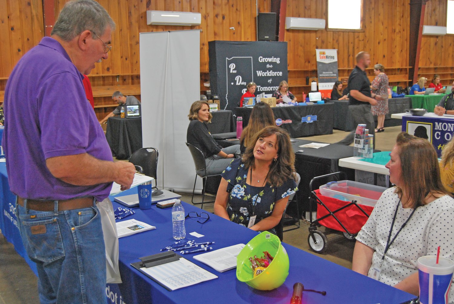 David Kessler, first from left, speaks Thursday with Debbie Calder and Tammy Lucas of the Indiana Department of Transportation at the Crawfordsville/Montgomery County Job Fair at the Montgomery County Fairgrounds.