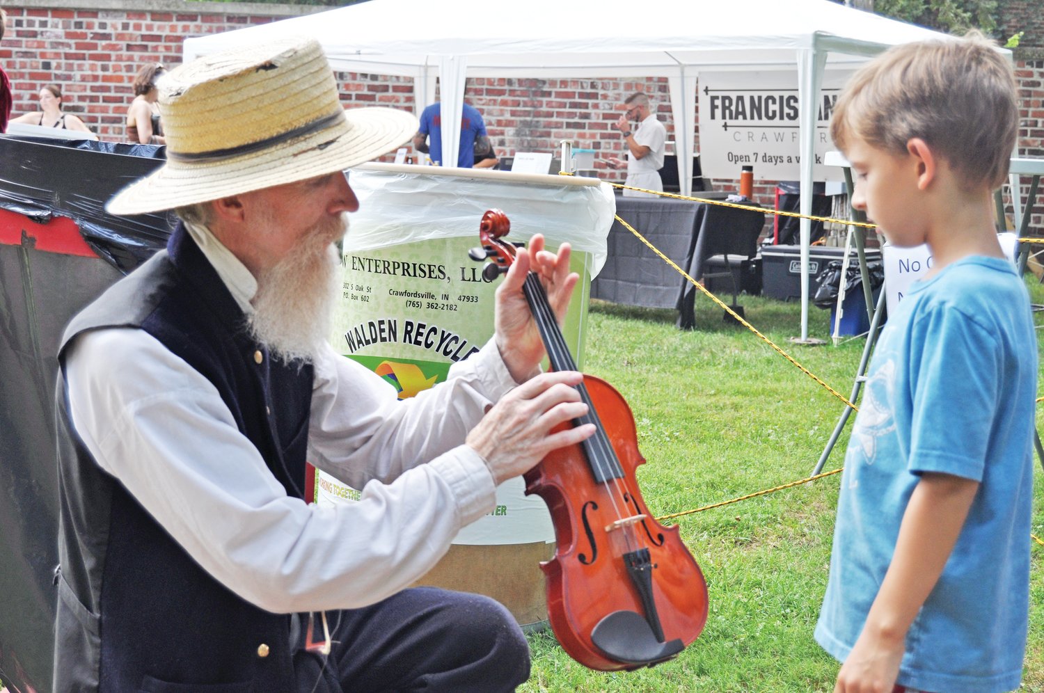 Gen. Lew Wallace (Bernie O’Bryan) shows a fiddle last year to Addis Helms at the Taste of Montgomery County.