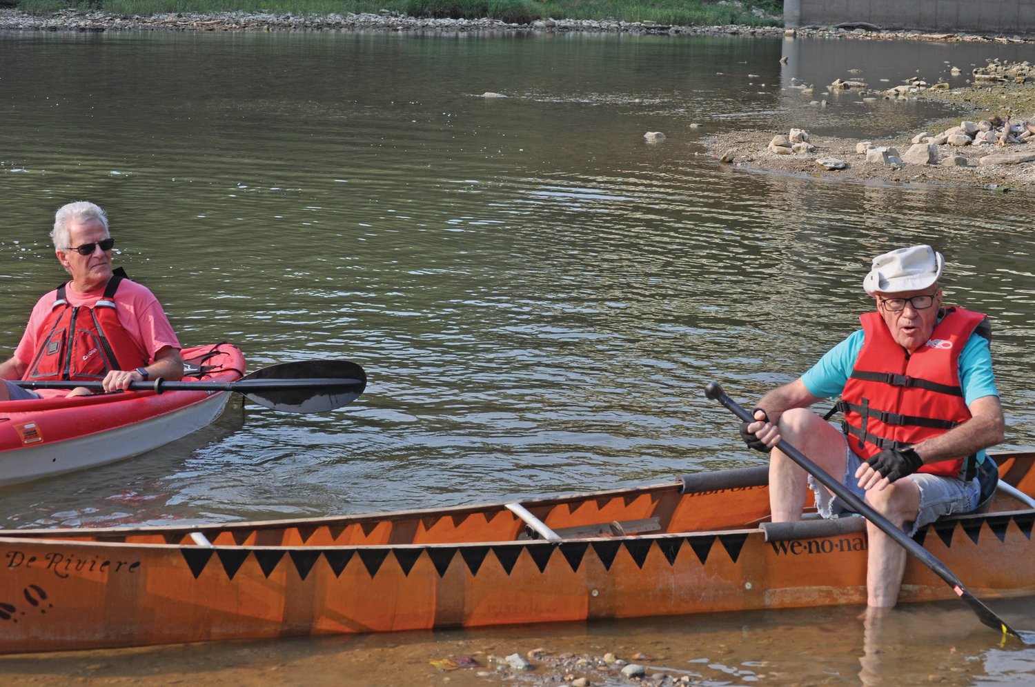 Bob Stwalley, right, talks to people gathered on the banks of Sugar Creek on Monday as Friends of Sugar Creek President Ed Fain looks on. Stwalley paddled through the old lowhead dam site.