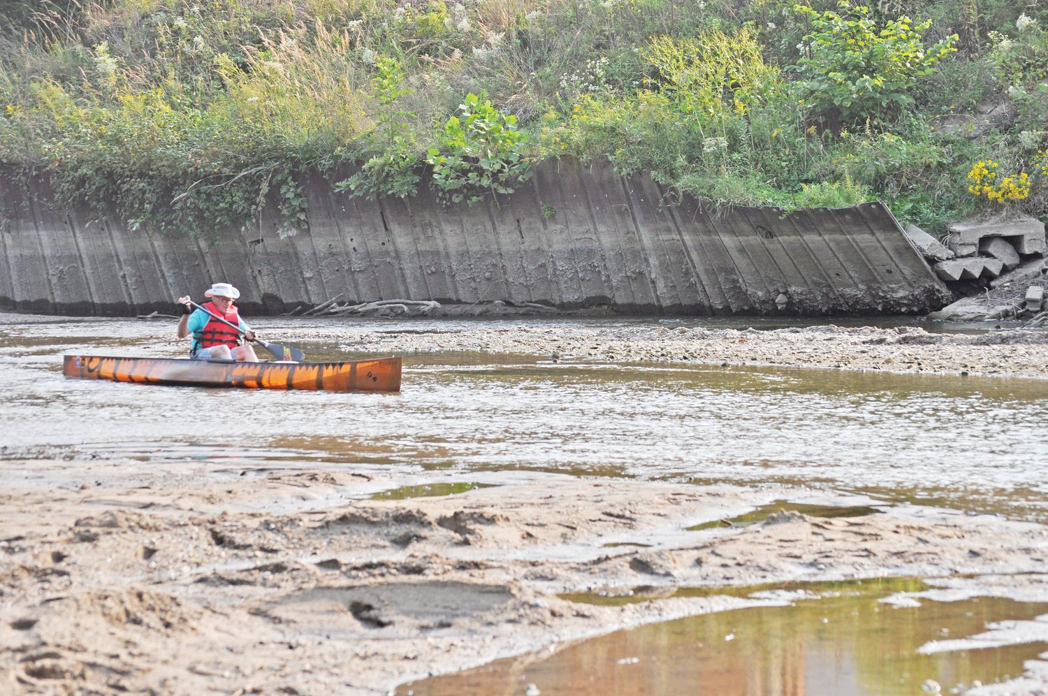 Bob Stwalley paddles through the old lowhead dam site on Sugar Creek on Monday.