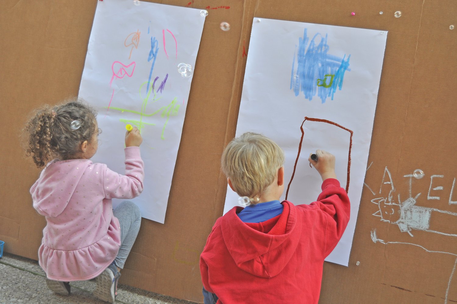 Children from Rainbows & Rhymes Preschool and Child Care draw pictures outside the Montgomery County Community Foundation building on Wednesday. The foundation has set up art stations for people to make art alongside muralist Jenna Morello.