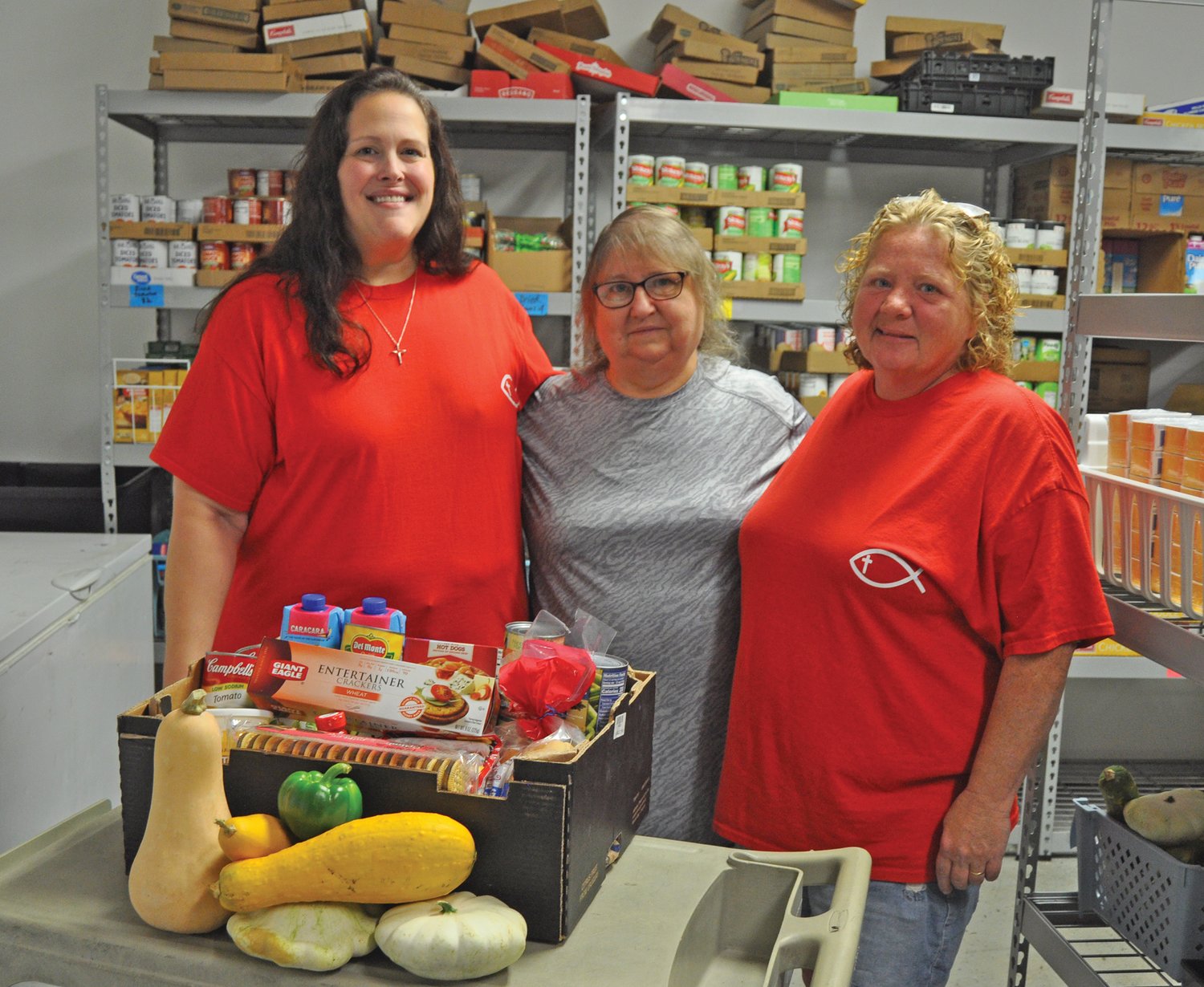 FISH volunteers Kara Kochell, from left, Martha Adair and Ellen Simpson in the food pantry on Thursday. The ministry is in need of more volunteers.