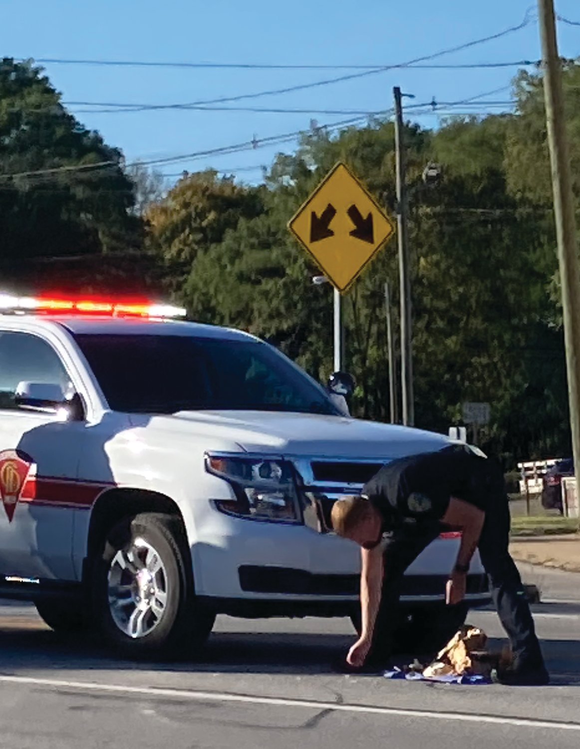 A Crawfordsville police officer gathers items from the roadway following a pedestrian crash involving a Crawfordsville Fire Department vehicle near downtown on Monday.