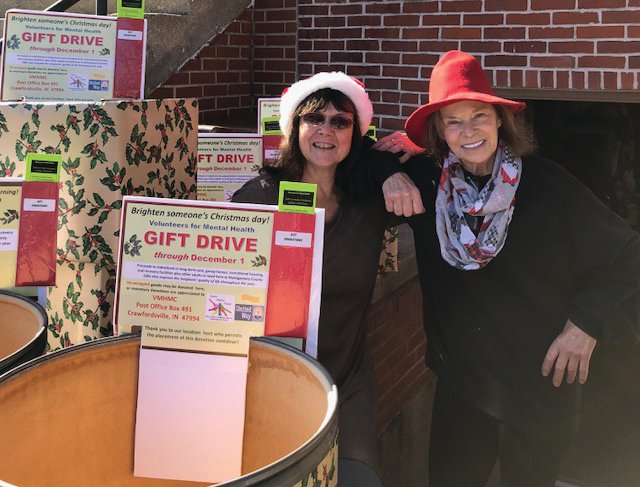 Ellen Ball, left, and Kym Bushong, chair of the Volunteers for Mental Health in Montgomery County Christmas Drive, prepare to roll out the barrels.
